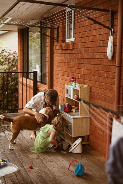 image of family on back verandah playing with toy kitchen