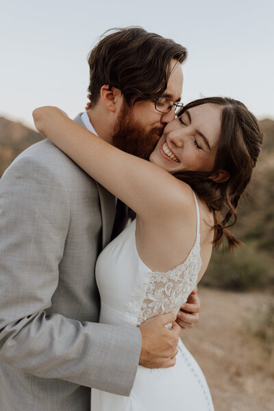 groom kissing brides cheek