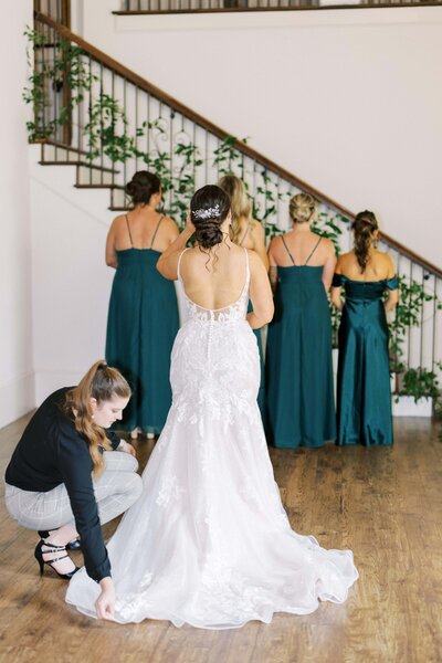 Bride in swan like dress laying on floor with a bid colorful bouquet in hands