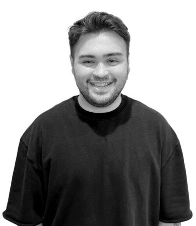 Male Art Director wearing a relaxed black t-shirt, showcasing creativity and expertise in professional hair artistry.