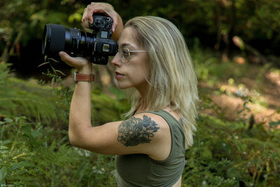 photographer woman holding canon cameras and tattoo