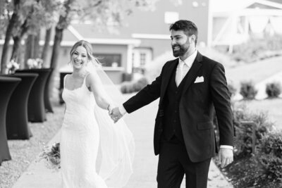 Bride and groom holding hands walking along at Finger Lakes wedding, New York