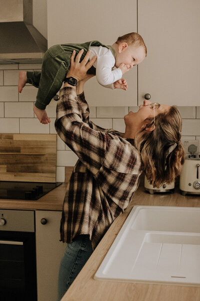 Mother holding baby in natural light home session Buxton High Peak