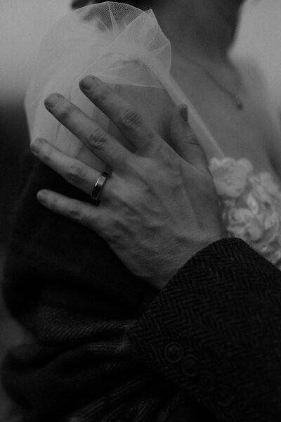 Close-up cinematic shot of a groom's wedding band, photographed in fine art black-and-white by Scottish wedding photographer Aly Robinson.