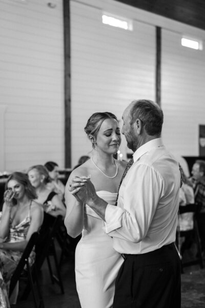 black and white image bride dancing with her father