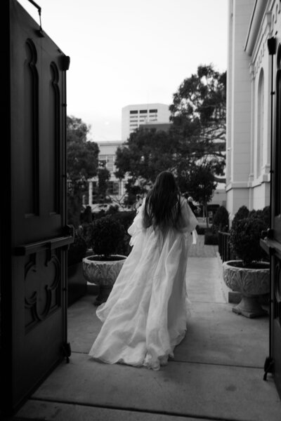 bride walking away from photographer while wearing wedding dress
