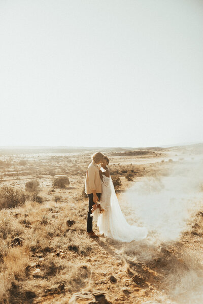 Just married couple leaning together in desert elopement