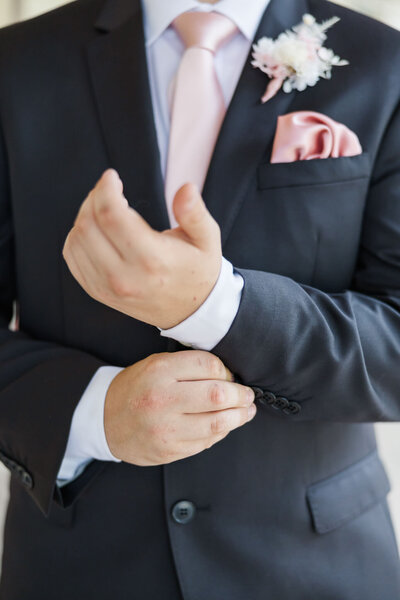 A close up image of a girl's hand holding a clutch with a corsage on her wrist.