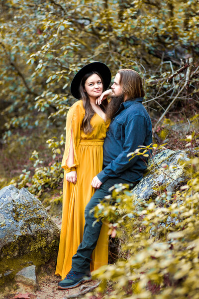 Engaged couple standing close, sharing a heartfelt, quiet moment. Their deep connection is captured in an elegant and timeless outdoor setting.