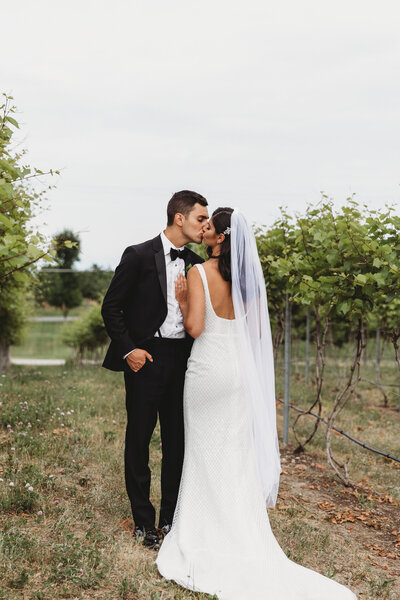 traverse city bride and groom kissing in vineyard