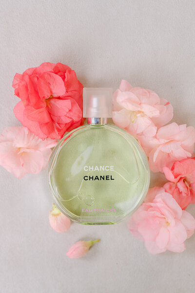 Bottle of Chanel perfume surrounded by florals