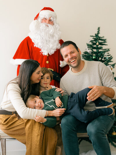 Family laughs with Santa together during a photoshoot in Amsterdam, Netherlands. 