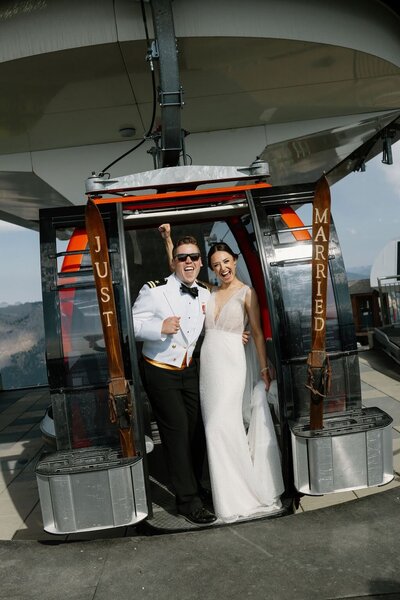 Bride and groom in military formals celebrating on Crystal Mountain gondola after wedding ceremony near Mount Rainier!