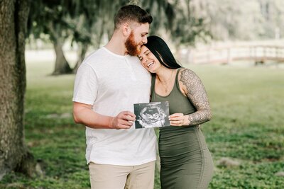 Mom and dad to be hugging with a sonogram in Orlando