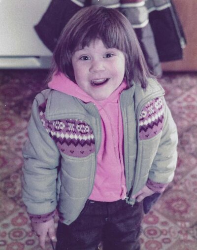 Jen Heller as a child in a pink and grey coat