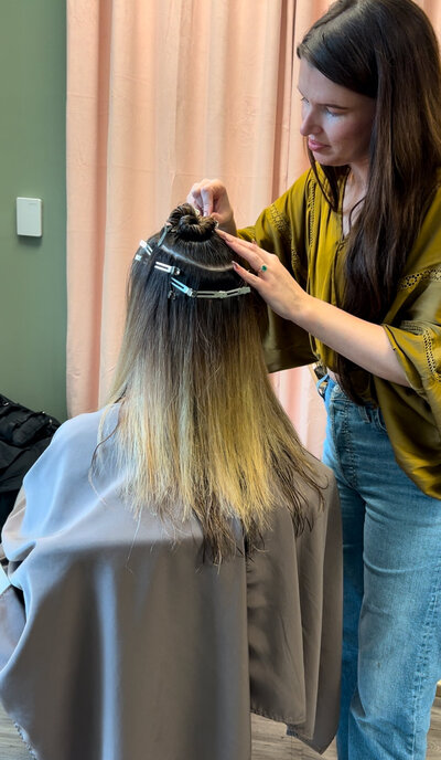 Jacqueline Redd Roberson applying the best hair extensions in hand tied wefts and k tips in Madison, MS