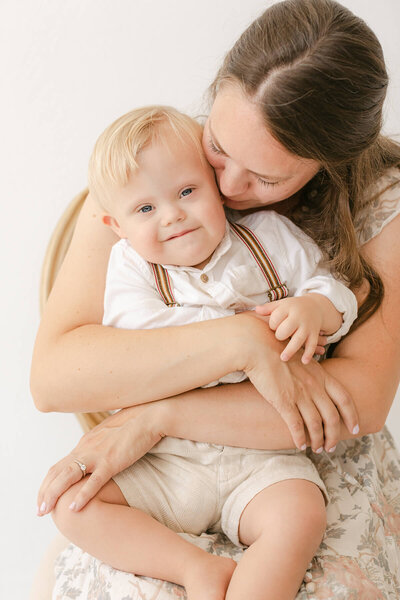 image of sweet little boy with special needs sharing a hug with his mom during their omaha family photography session