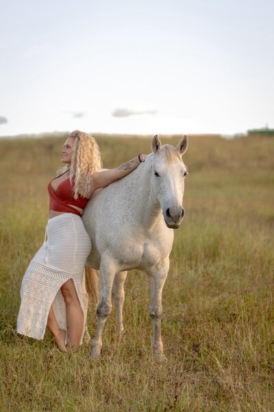 Woman leaning on side of horse in fully trust  during horse retreat in australia.