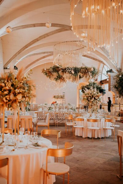 Salle de mariage avec tables et décor luxueux. Scénographie imaginée par une organisatrice d'événements.