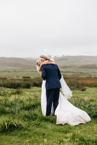 bride and groom dancing in field on estate in tomales bay