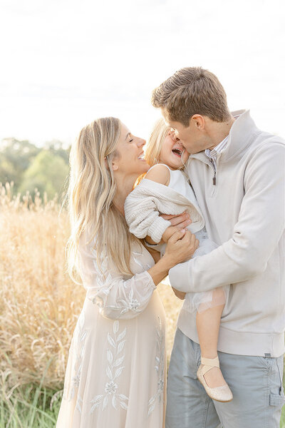 parents kissing daughter during Fauquier County, Virginia family picture