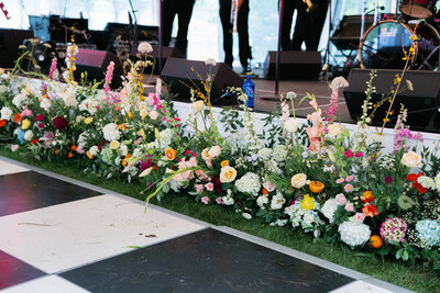 Florals lining stage with black and white checkered floor
