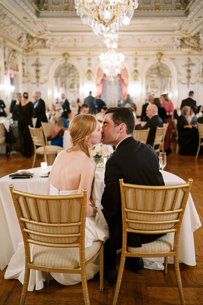 Bride and groom sharing a quiet kiss during estate reception, photographed by Luxury Wedding Photographer Seattle DC.