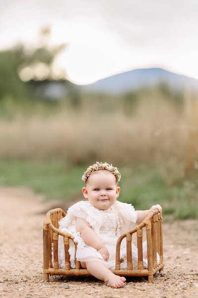 baby girl sitting in a cute outfit in a field in denver colorado