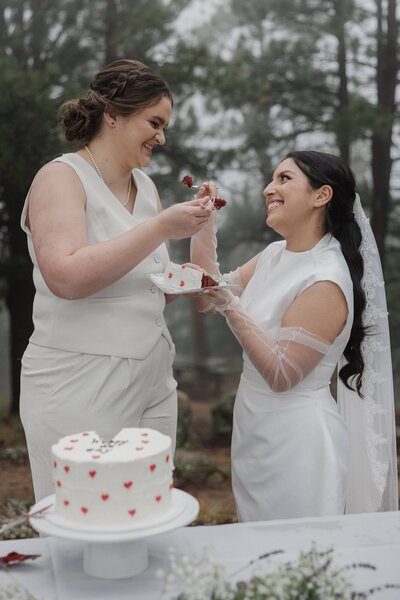 LGBTQ couple feeds each other cake during Boulder small wedding.