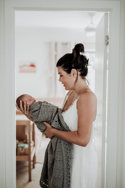 mother holding baby in home lifestyle portraits
