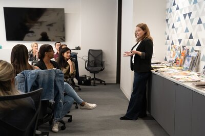 woman in a black pantsuit doing a presentation