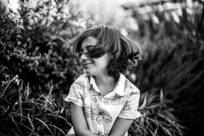 Black and white photo of little boy playing with his hair