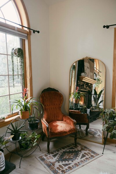 Gorgeous studio for photographers to rent in Lake Mills, WI with vintage, dark and moody aesthetic, vintage furniture, mirrors and plants