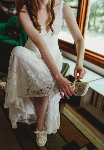 bride sitting down putting on shoes