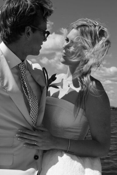Bride and groom sailing on a classic white sailboat during their romantic elopement in Annapolis, Maryland, with the Chesapeake Bay in the background