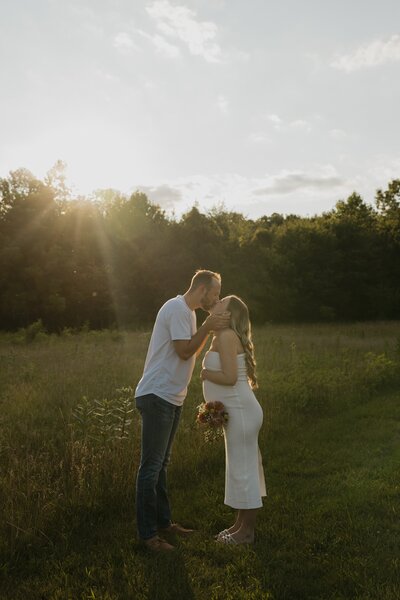 maternity photo in a field at golden hour