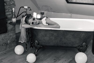 Editorial portrait of a black bride holding her veil while resting at the Bow's Bridge.