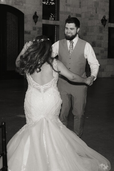 couple laughing and smiling at each other during their adventure session on a mountain top