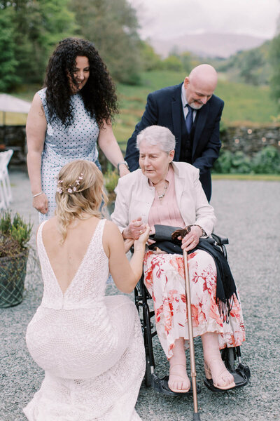 bride greeting her grandmother sitting in the wheelchair 