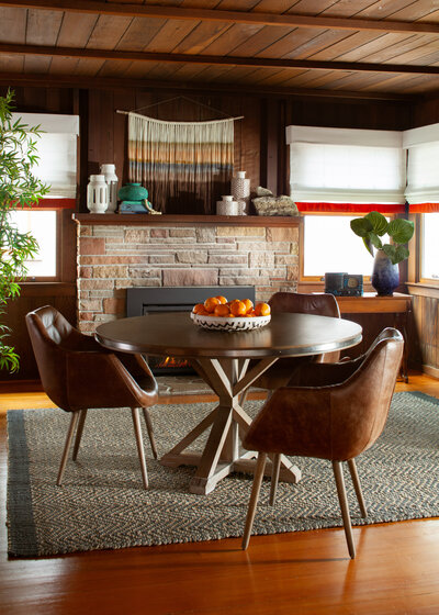 Interior design photography of a cozy dining room with a fireplace and round table.