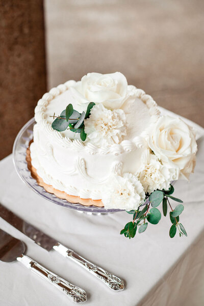 Detail photo of white cake with flowers that's included in elopement packages
