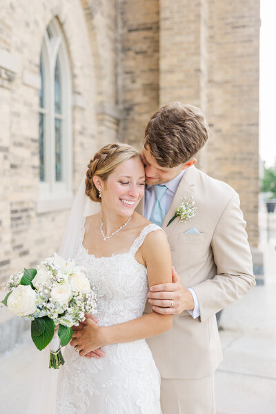bride and groom embracing outside a Catholic church