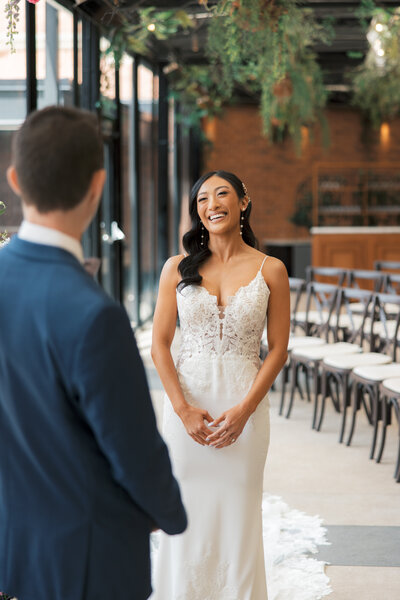 Wedding photography of a bride smiling at groom during their first look at Solarium at the Ritz Carlton in St. Louis