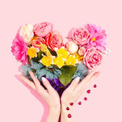 Hand's holding colorful flowers
