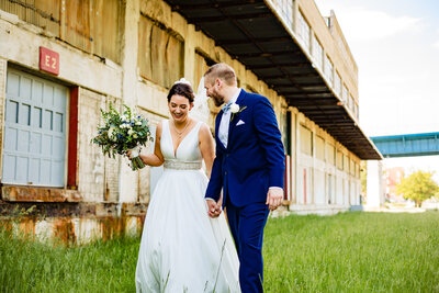 A wedding couple holding hands while walking through Middlegrounds Metro park in Toledo Ohio