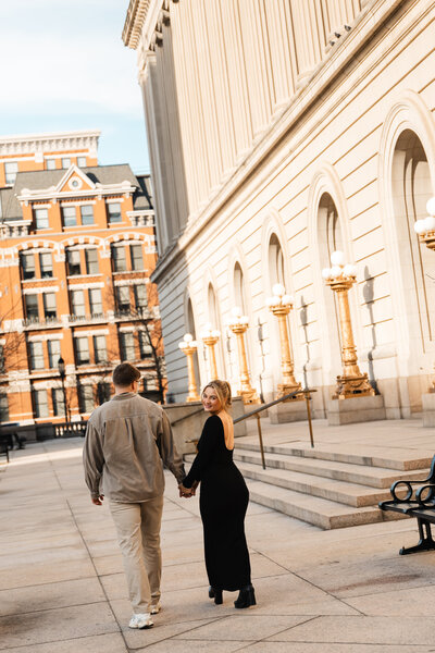Elegant engagement photo of a couple in downtown Cincinnati, dressed in chic outfits with luxury vibes and the city.