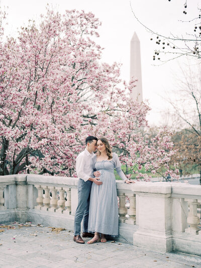 Couple stand together on balcony of the DAR Constitution Hall during their maternity session.