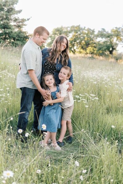 family embracing in wild flower field
