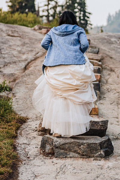 Bride climbing stairs near mountains at Artist Point in Baker, Washington