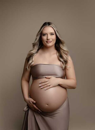 Mom showing off baby bump towards the camera while taking a fine art maternity portrait. Jenni Nikki specialized in Maternity and Family photography in Alpharetta, GA.